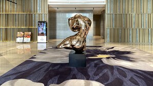 A lobby with a modern design, featuring a metallic sculpture on a patterned rug, a reception desk, and vertical paneling on the walls. - La Yarda Hotel Guangzhou - Free Shuttle Bus Available during Canton Fair Period (Guangzhou)