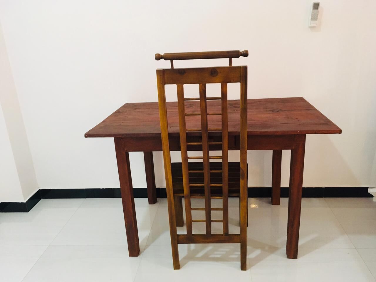 A wooden dining table with a chair in front.