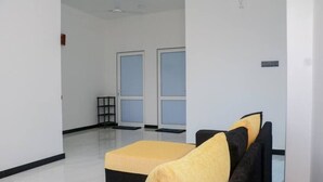 A room with a large window, a sofa, and a small table. - Villa Serenity (Weligama)
