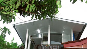A house with a staircase leading to a balcony, surrounded by greenery and a red railing. - Villa Serenity (Weligama)