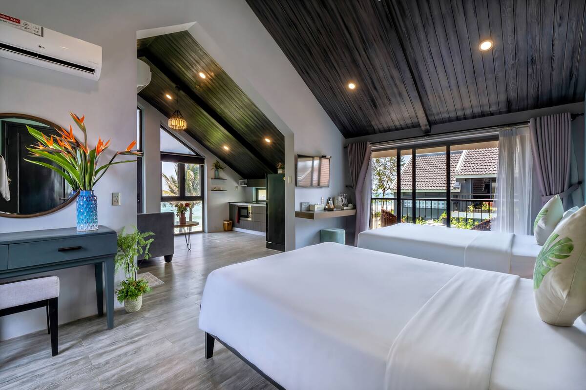 Une chambre d’hôtel moderne, dotée d’un grand lit, d’un bureau et offrant une vue sur l’extérieur.