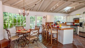 Una cocina con una isla central, sillas de madera y un candelabro.