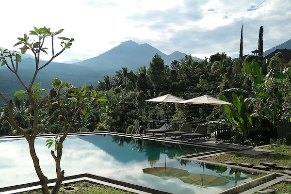 Una piscina al aire libre, sillones reclinables de piscina