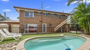 A two-story house with a swimming pool, a fenced backyard, and a staircase leading to the upper floor. - Serene Family Escape with Pool (WOORIM)