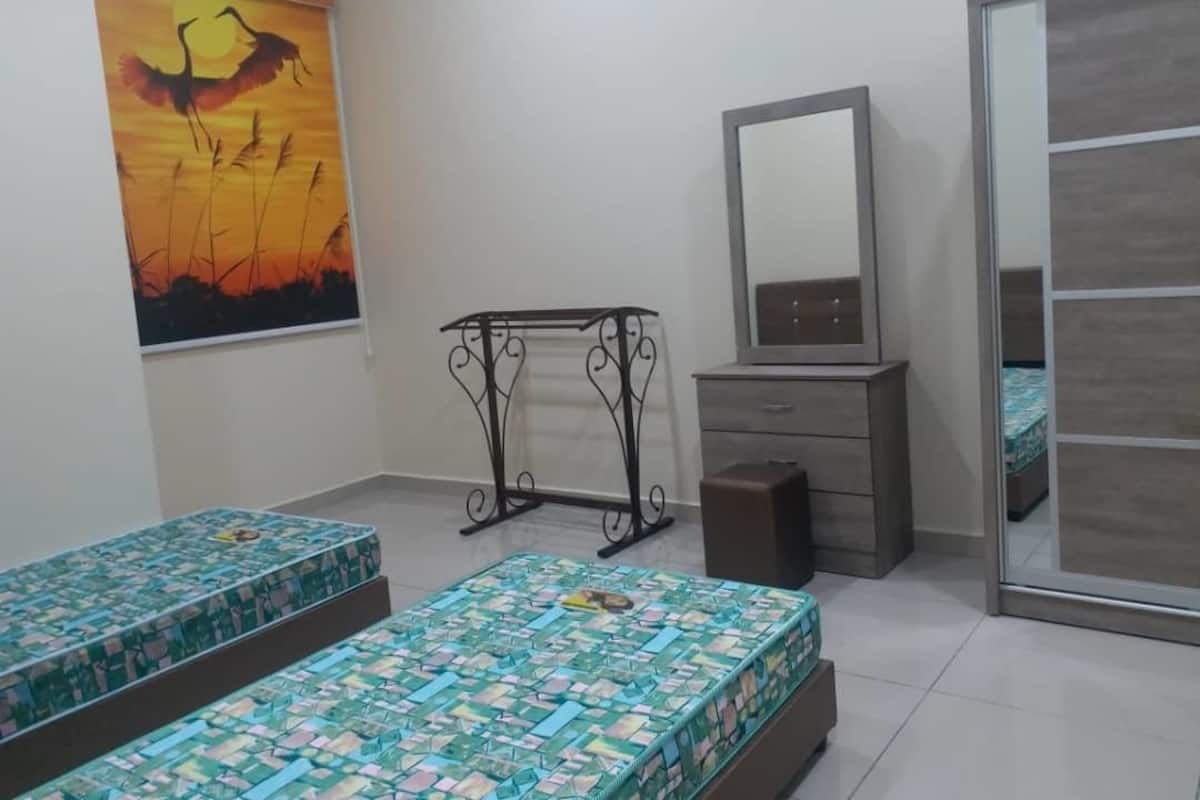 A bedroom with two beds, a dresser, a mirror, and a painting on the wall.