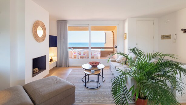 A modern living room with a balcony, a round mirror, a small table, a sofa, and a potted plant. - Frontline apartment with garden and pool. Parking . Capacity 4 Persons. WIFI (PALS)