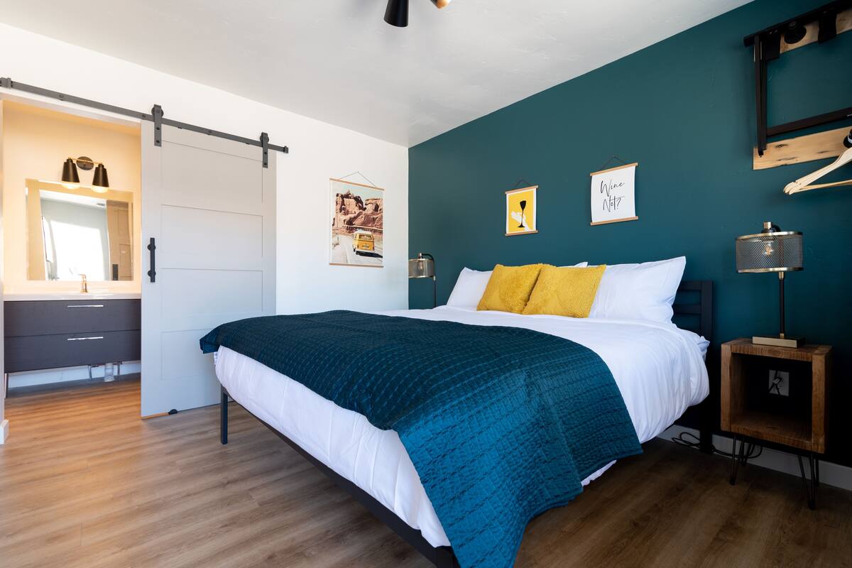 Une chambre à coucher avec un lit, une table de chevet, un miroir et une porte coulissante.