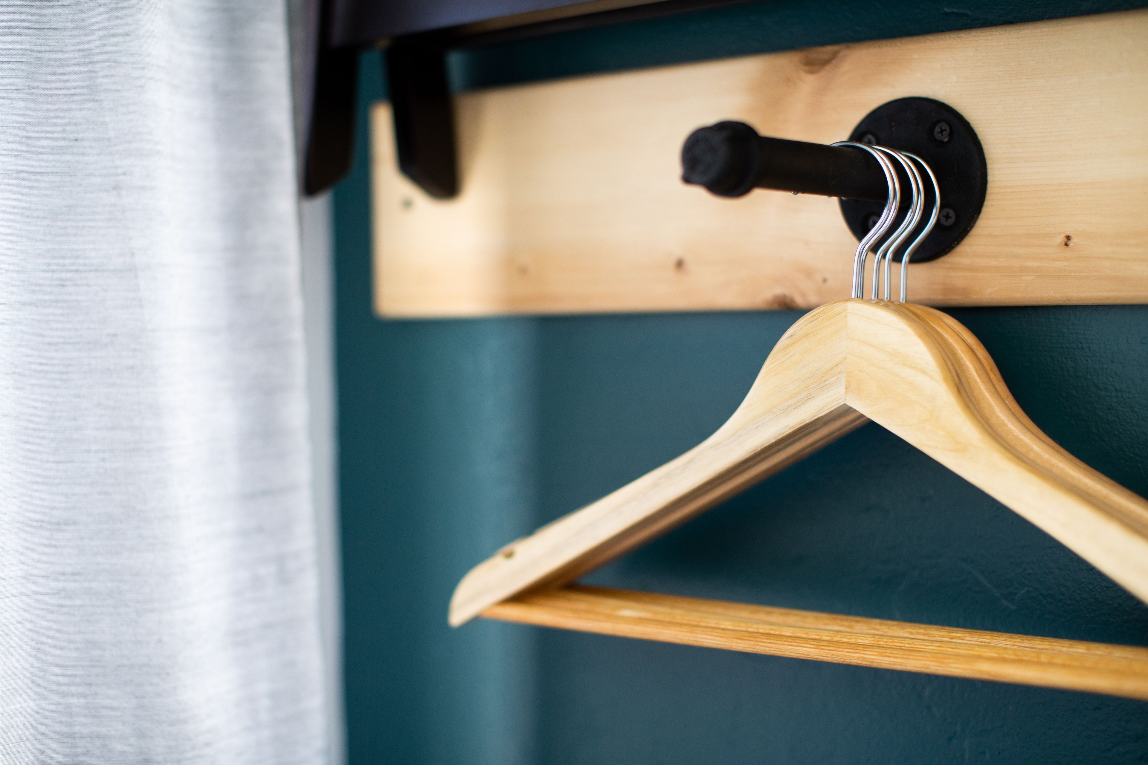 A wooden hanger on a wall-mounted rack.