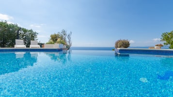 Piscine à débordement, chaises longues