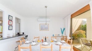 Een eetgedeelte met een tafel voor vier personen, een keukenbar en uitzicht op de omgeving.