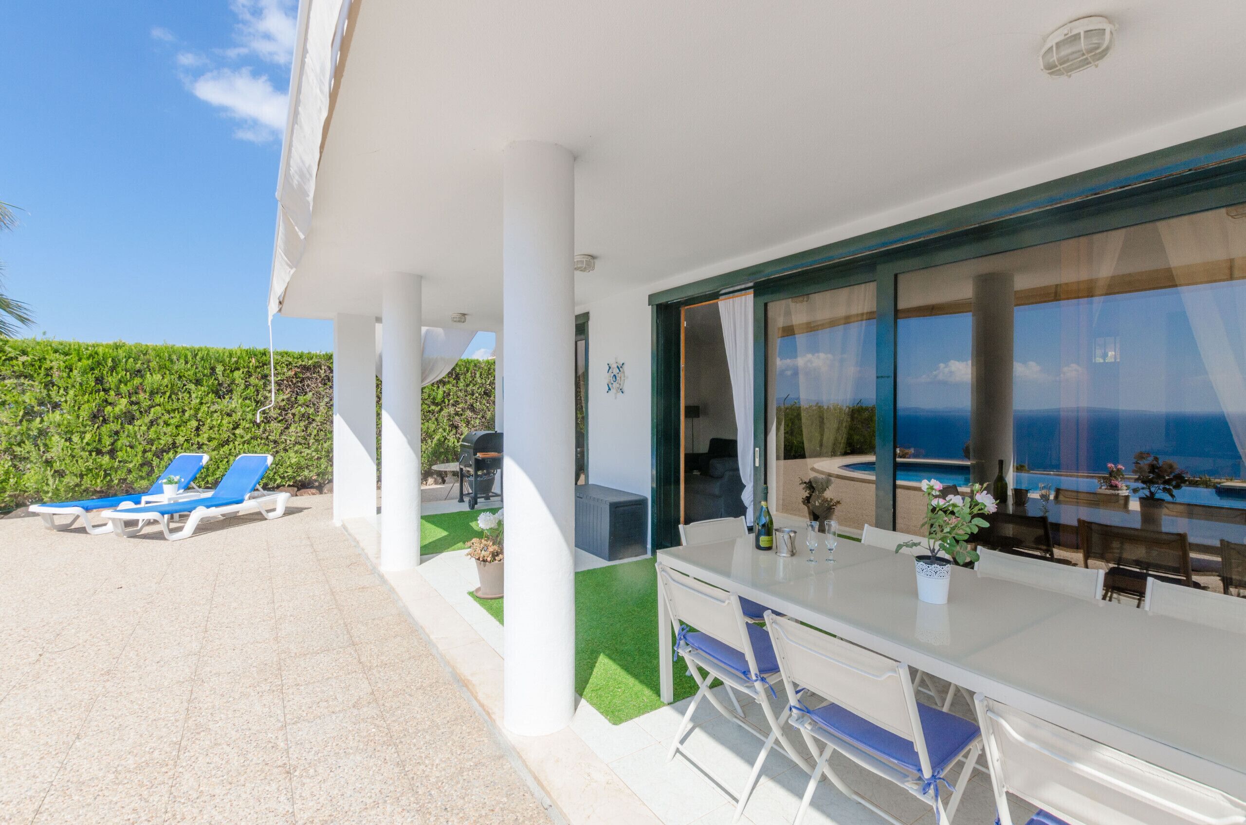 Un espace extérieur abrité comprenant une table de billard, des fauteuils et une vue sur la mer.