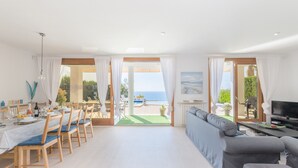 Een ruime woonkamer met een grote bank, een eethoek met stoelen en een televisie.