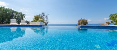 An infinity pool, pool loungers