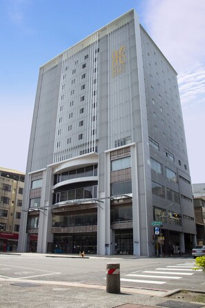 A modern building with a prominent entrance and a large glass facade. - Hu house (Kaohsiung)