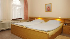 A double bed with two pillows, a bedside table with a lamp, and a framed picture on the wall. - Ferienhof Jens Apartment 4 - Apartment 4 (Kronsgaard)