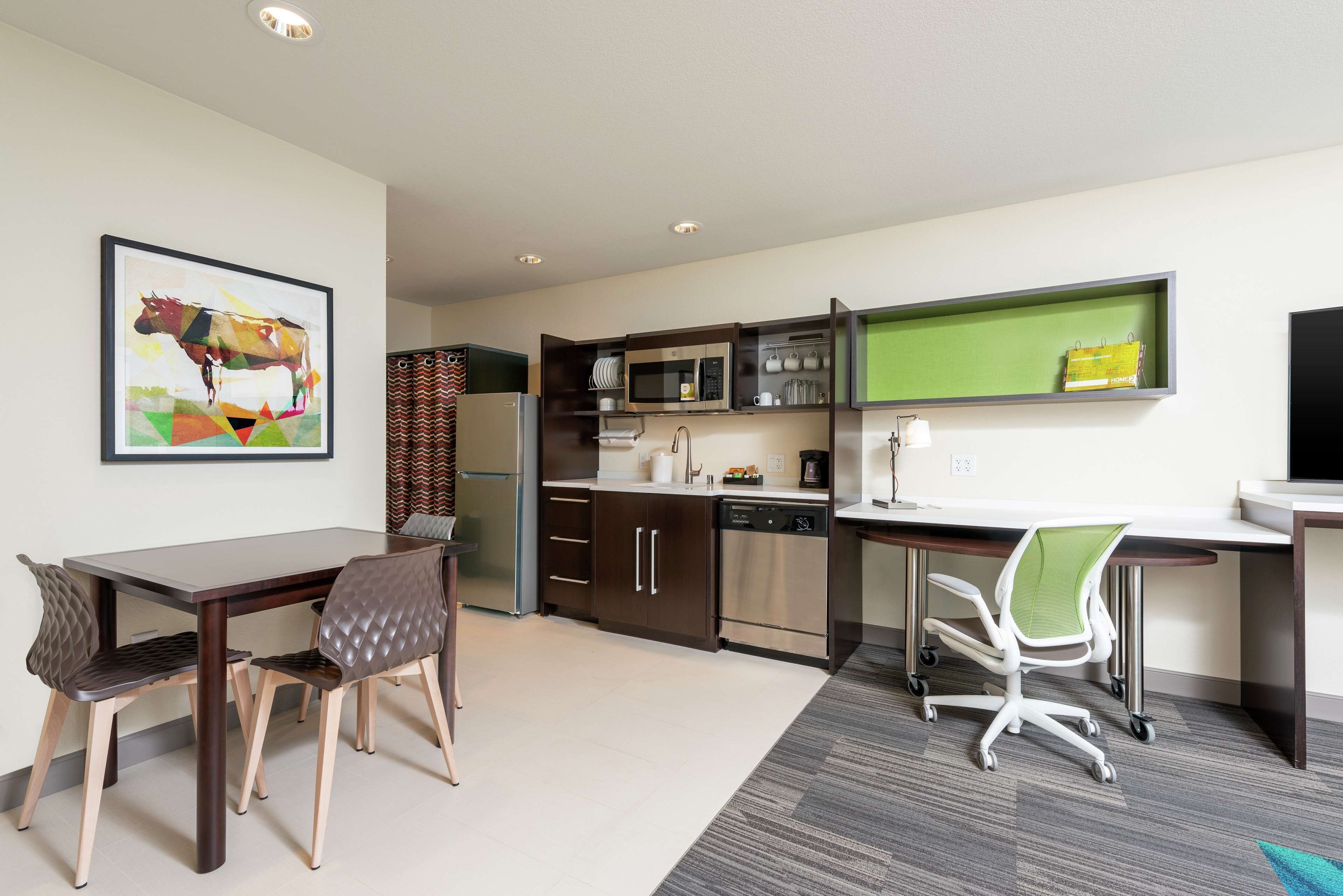 A modern kitchen with a dining area, featuring a microwave, oven, and dishwasher.