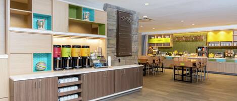 Un moderno vestíbulo de hotel con mostrador de recepción, zona de estar y estación de café.