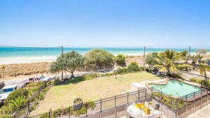 Uma área residencial com piscina, vista para a praia e quintal cercado.