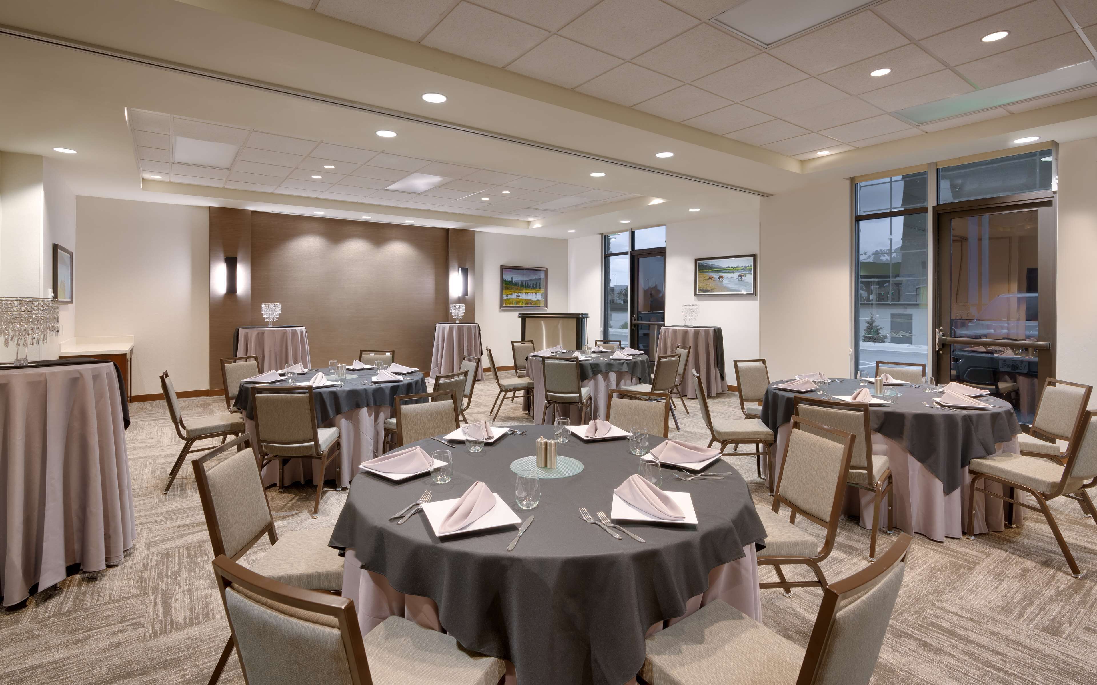 A conference room with round tables, chairs, and a large window.