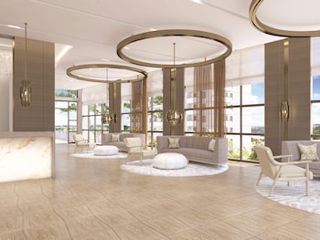 Relax in a spacious living area with a curved ceiling, comfortable seating, and expansive views of the surrounding landscape. at Amrit Ocean Resort and Residences - Singer Island