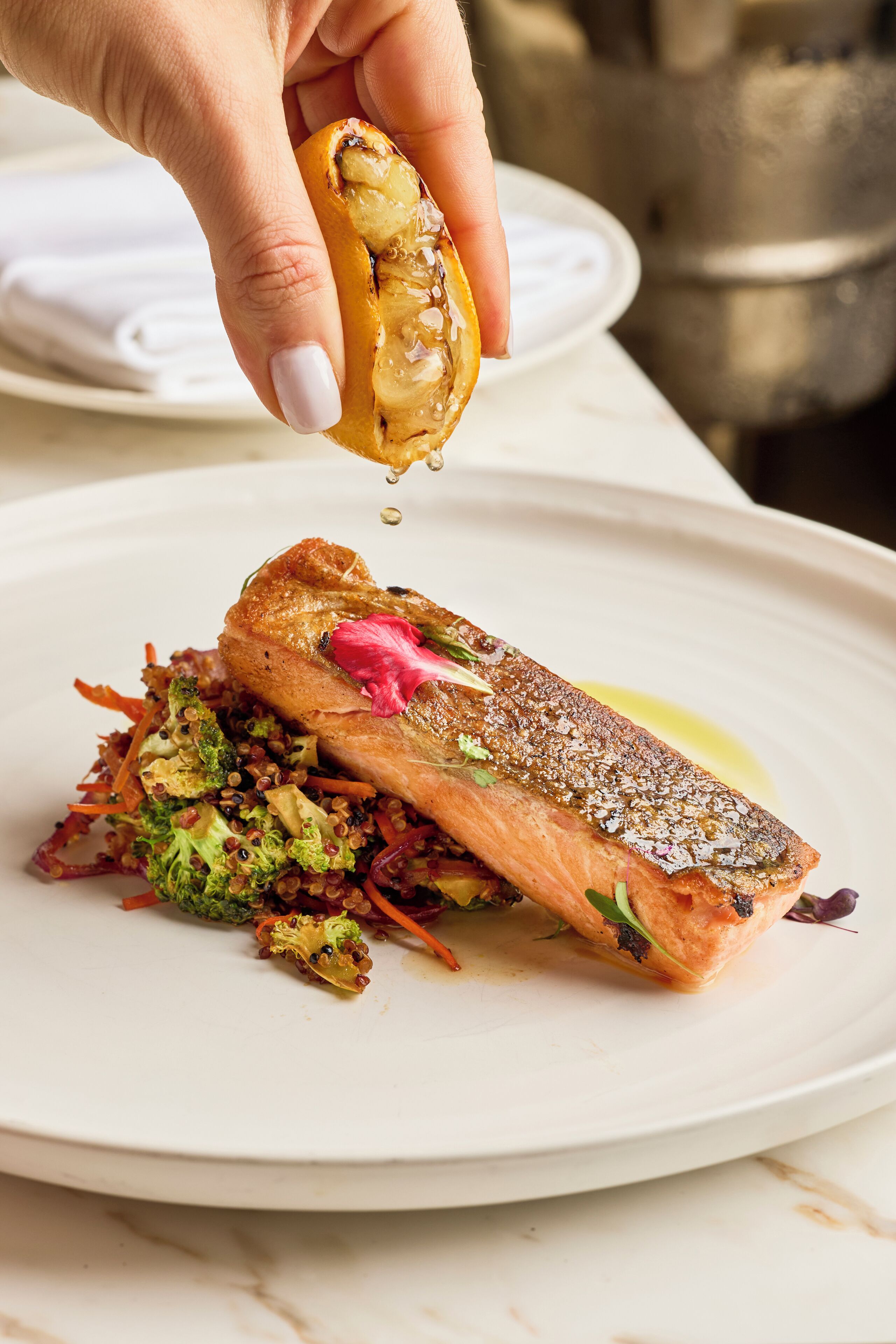 A plate of food with salmon, broccoli, and carrots.