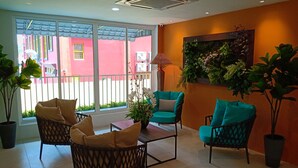 A room with wicker chairs, a table, and potted plants. - H Boutique Hotel Xplorer Loke Yew (Kuala Lumpur)