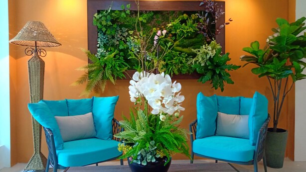 A room with two turquoise armchairs, a wooden coffee table, a potted plant, and a wall-mounted green plant display. - H Boutique Hotel Xplorer Loke Yew (Kuala Lumpur)