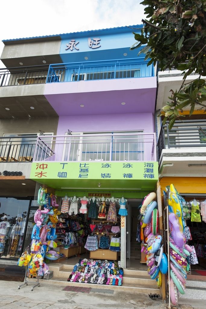 Um edifício com fachada colorida e uma placa de identificação sobre a entrada.