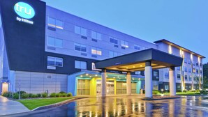 A modern hotel with a prominent 'tru by Hilton' sign, a covered entrance, and a well-lit facade. - Tru by Hilton Middletown (Middletown)
