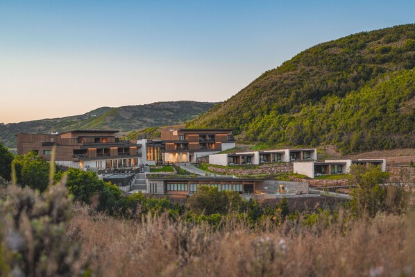 Ein moderner Wohnkomplex mit mehreren Häusern, eingebettet in eine natürliche Landschaft und Hügellandschaft.