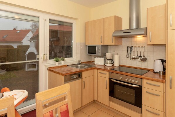 A compact kitchen with a microwave, coffee maker, and oven.