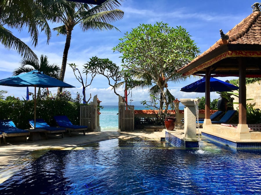 Una piscina al aire libre, sombrillas, sillones reclinables de piscina
