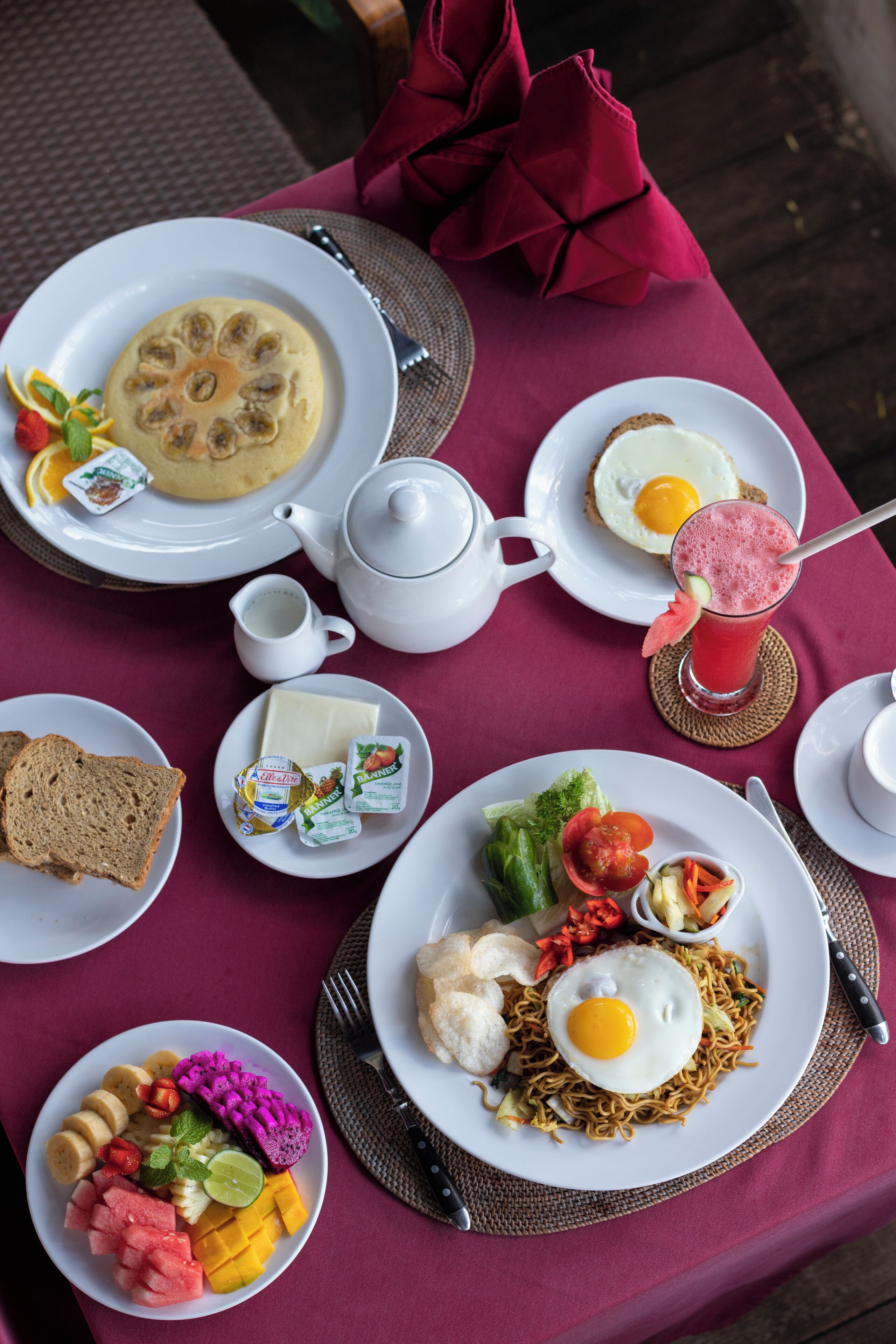 A table set with breakfast items including eggs, toast, and various fruits.