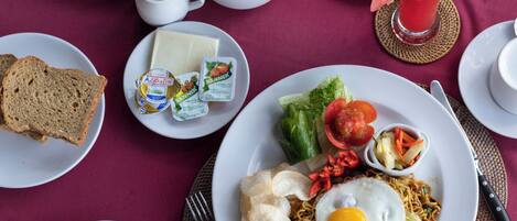A table set with breakfast items including eggs, toast, and various fruits.