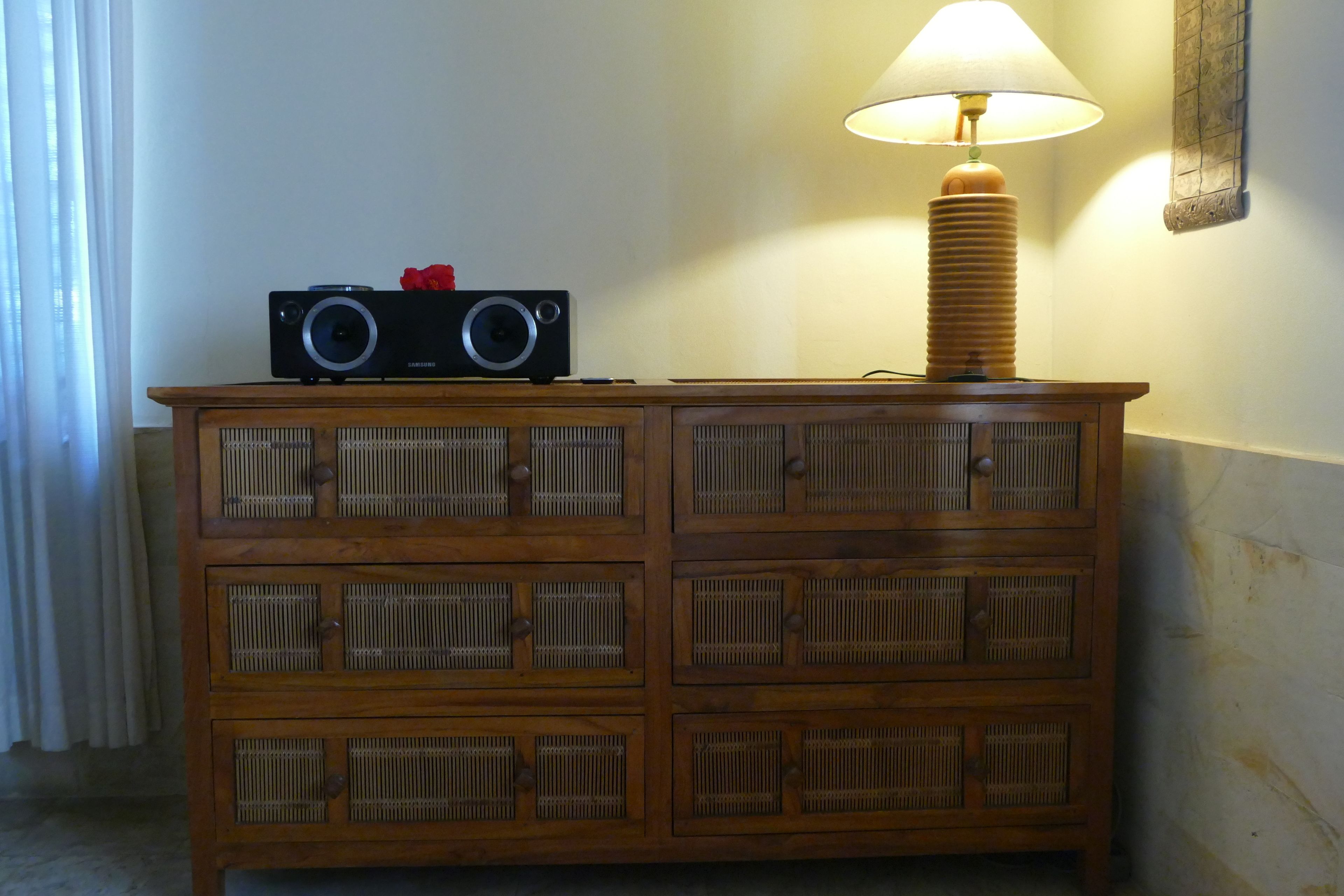 Un mueble de madera con una radio y una lámpara.