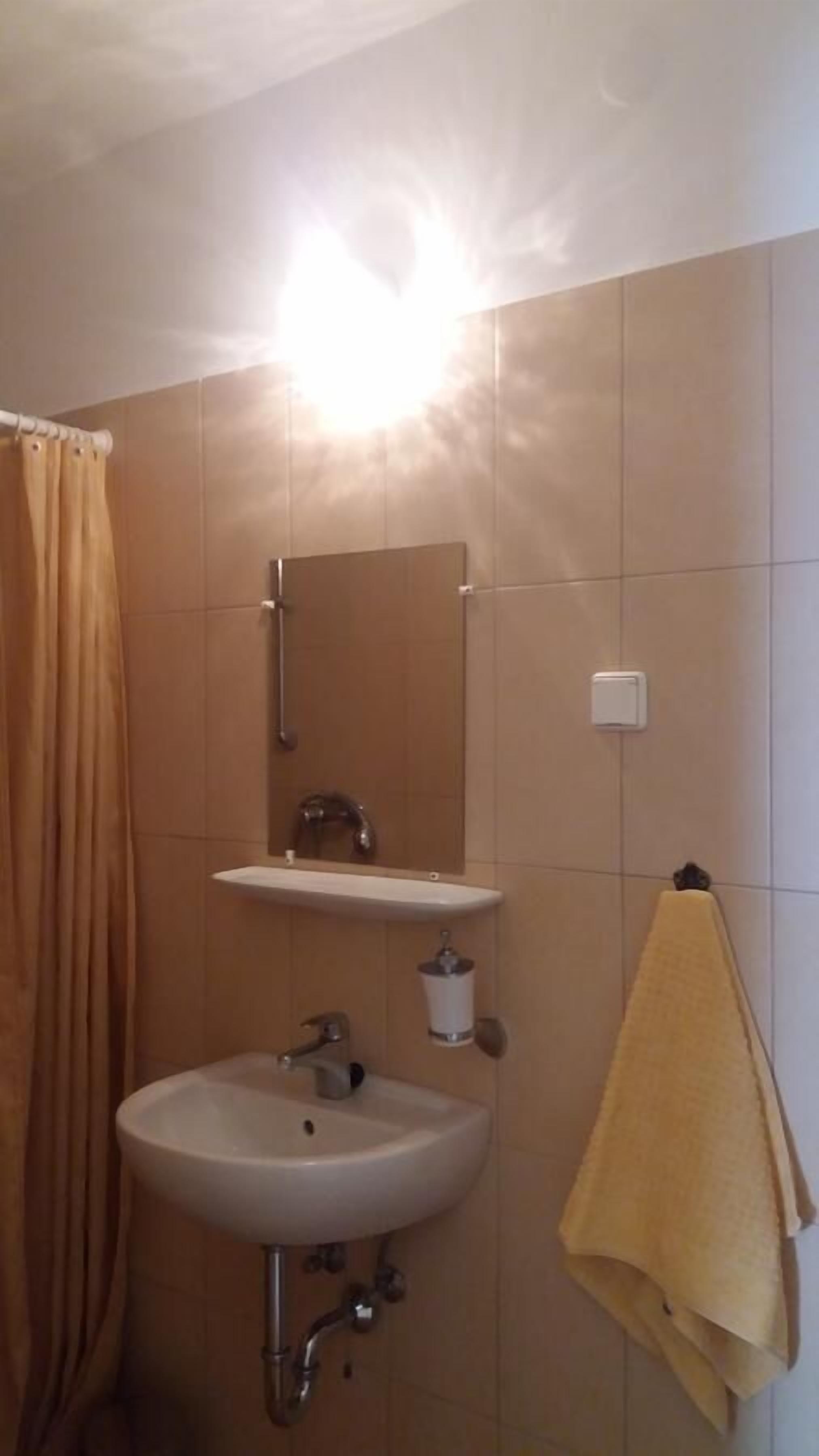 A bathroom with a sink, mirror, and towel rack.
