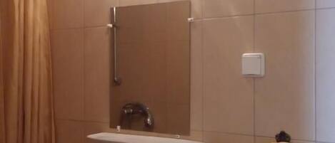 A bathroom with a sink, mirror, and towel rack.