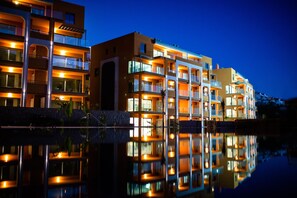 A multi-story hotel with balconies and a reflective pool in front. - Arguineguin Park By Servatur VV (Mogan)