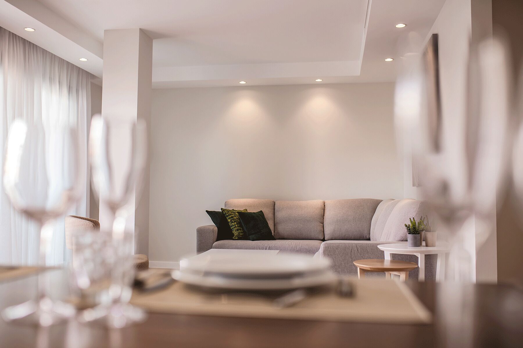 A modern living room with a sofa, a small round table, and a coffee table.