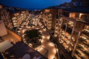 A multi-story hotel with a central courtyard, outdoor seating, and balconies. - Arguineguin Park By Servatur VV (Mogan)