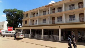 A multi-story hotel with balconies and a covered entrance.
