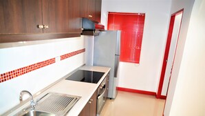A kitchen with a stainless steel sink, a built-in oven, and a refrigerator. - Luxury 1 bed Corner Condo (Pattaya)