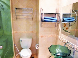 A bathroom with a toilet, a glass sink, and two towel racks with towels. - Studio Close to Jomtien Beach - Sleeps 2 (Pattaya)