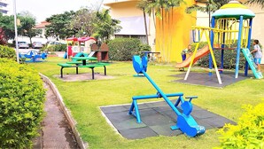 A playground with various equipment including swings, slides, and climbing structures. - Sea View Studio Jomtien (Pattaya)