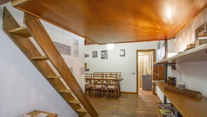 A wooden staircase leading to a dining area with a table and chairs.