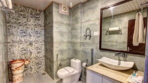 A bathroom with a toilet, sink, and shower area.