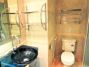 A bathroom with a black sink, a toilet, and a shower area. - Stylish Studio Rentbuythailand (Pattaya)