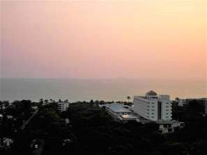A coastal hotel with multiple buildings, including a prominent white structure with a dome, surrounded by greenery and overlooking the sea. - 15th Floor Sea View Apartment - Sleeps 2 (Pattaya)