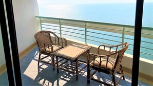 Ein Balkon mit Korbmöbeln und Blick auf den Ozean.