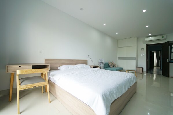 A modern bedroom with a wooden bed, a desk, and a chair.